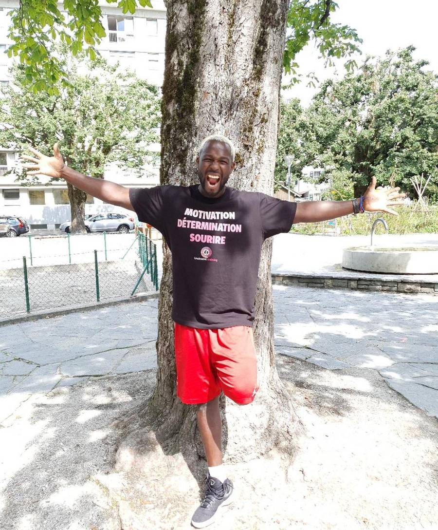 Steeve Louissaint, coach sportif fondateur de Louissaint Training, bras ouverts en t-shirt Motivation Détermination Sourire